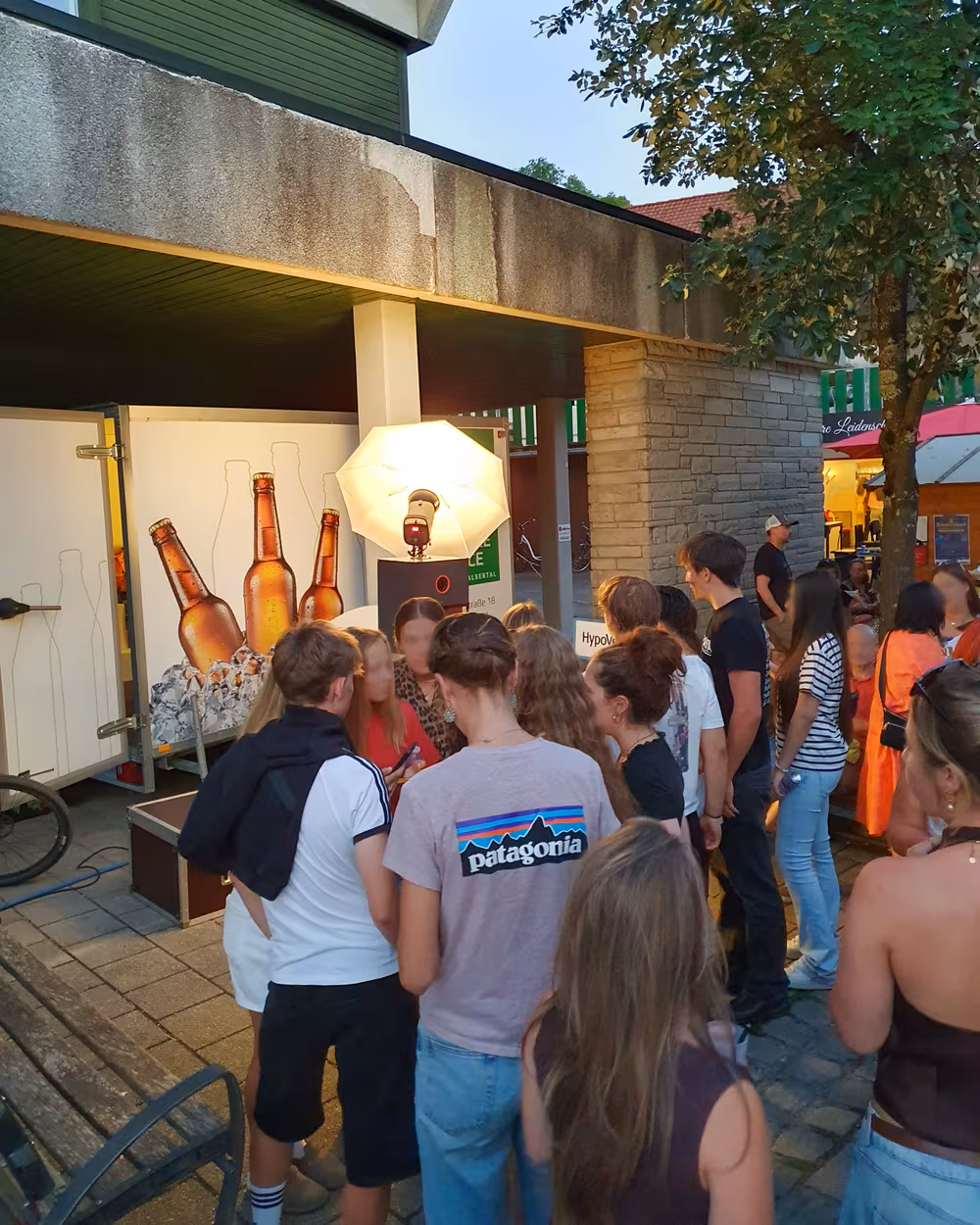 Gäste warten am Abend an der beleuchteten Fotobox beim Stadtfest Sonthofen