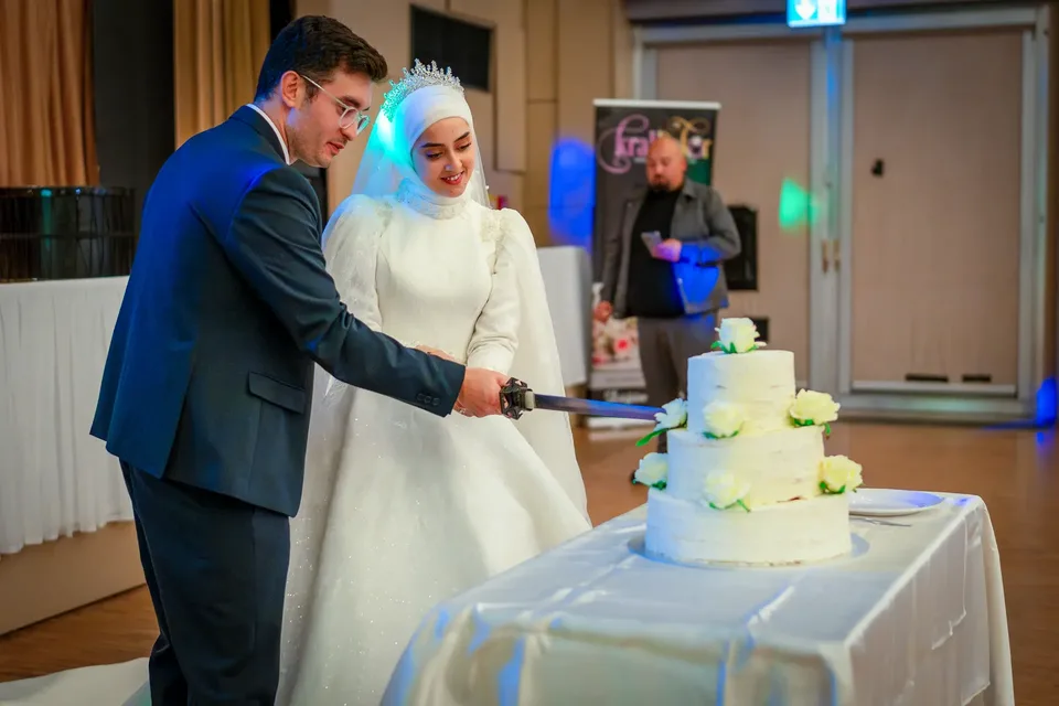 Brautpaar schneidet Torte mit Schwert