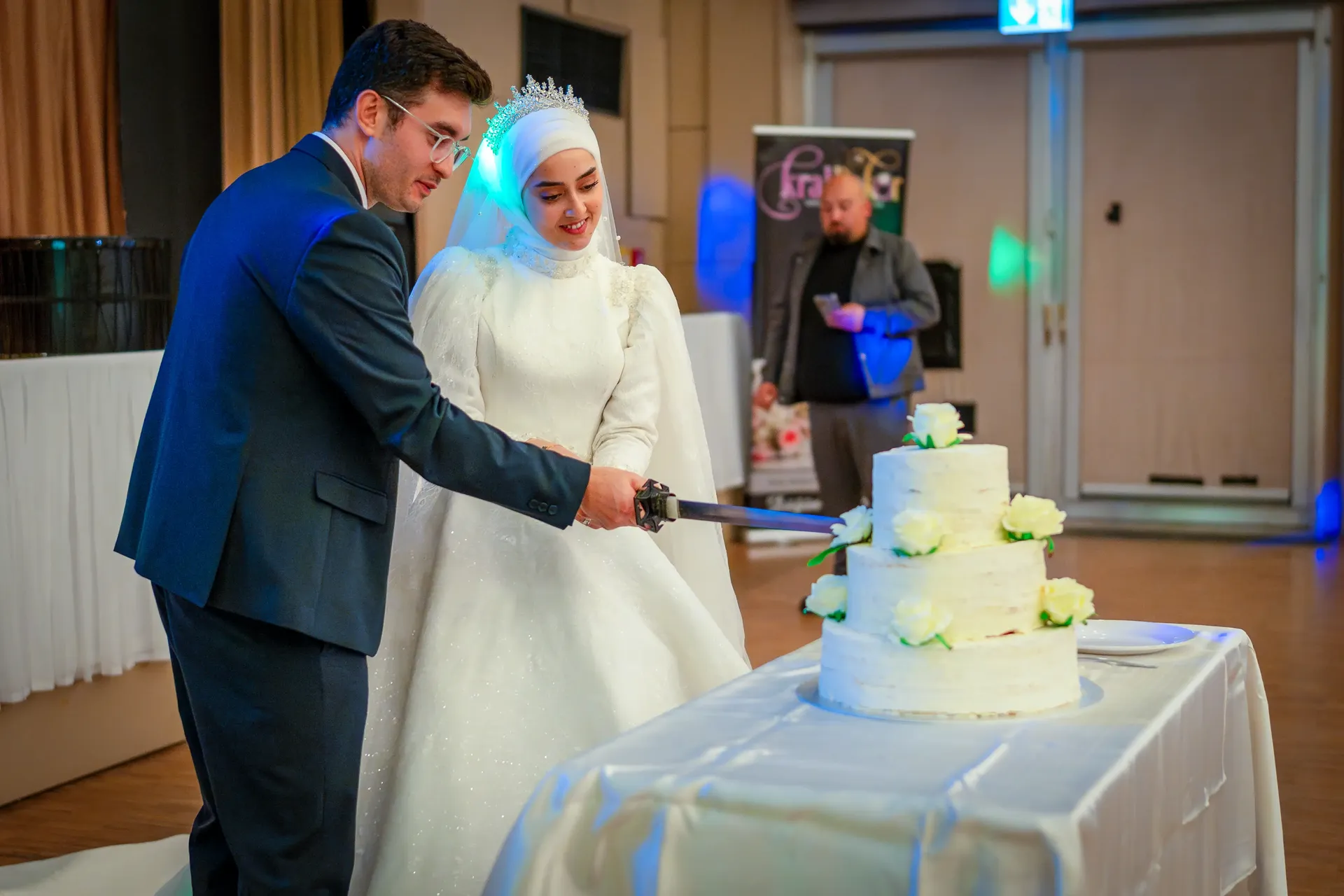 Brautpaar schneidet Torte mit Schwert