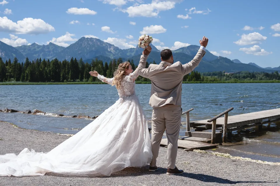 Jubelndes Brautpaar am Bergsee im Allgäu – ungestellter Moment nach der Trauung