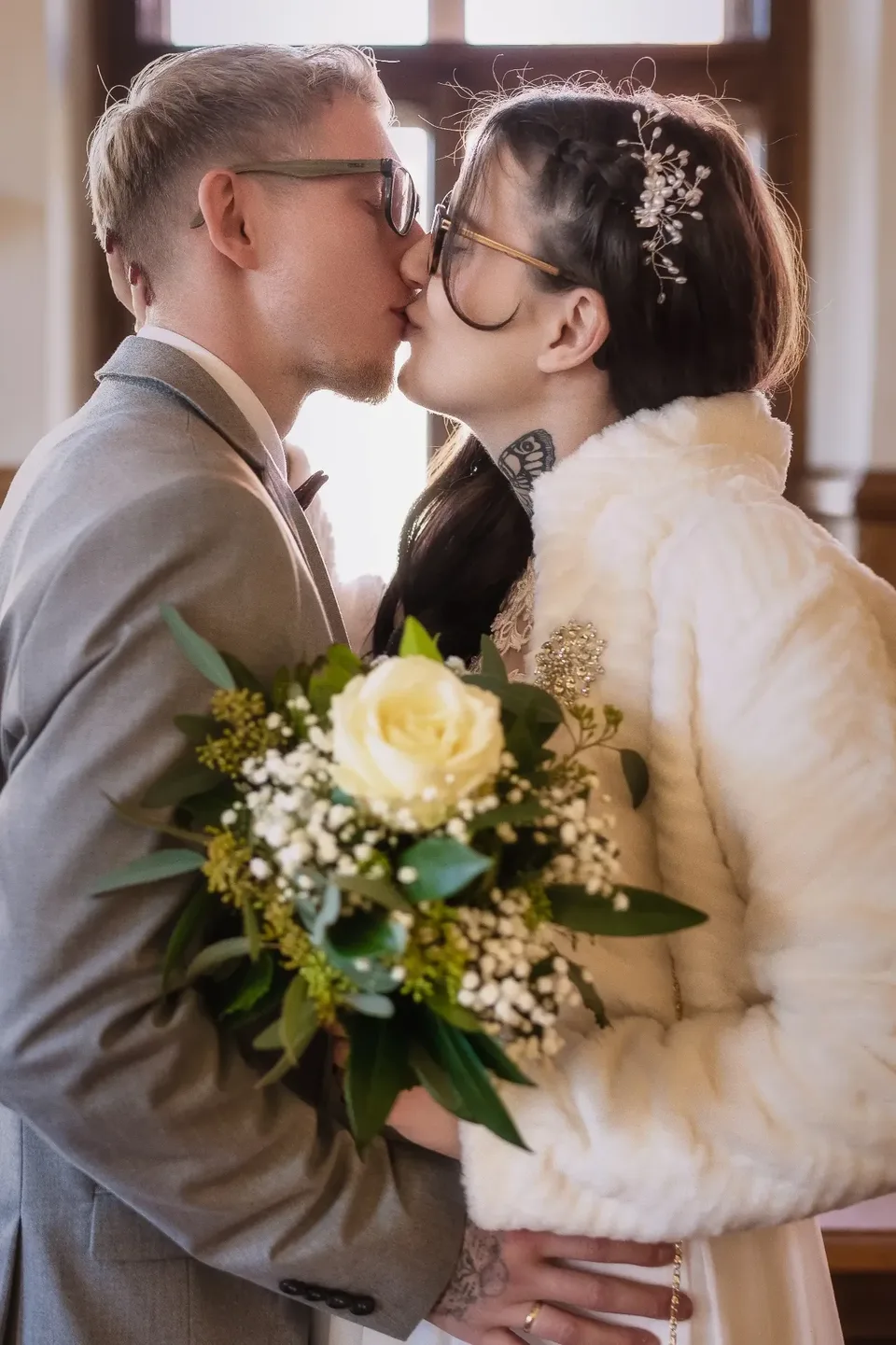 Brautpaar küsst sich, Winterhochzeit mit Fellstola